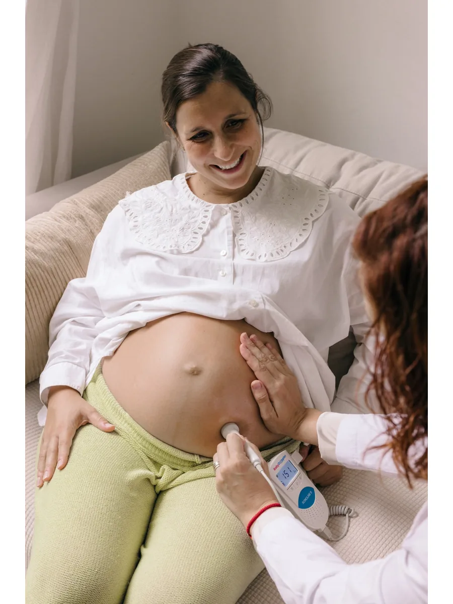 Elena Pajuelo, matrona online en Valencia, realizando control prenatal con Doppler a una embarazada sonriente
